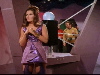 Female alien standing in front of black box; Kirk etc. in background