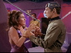 Spock grabs female alien; Kirk holds remove-control device in background